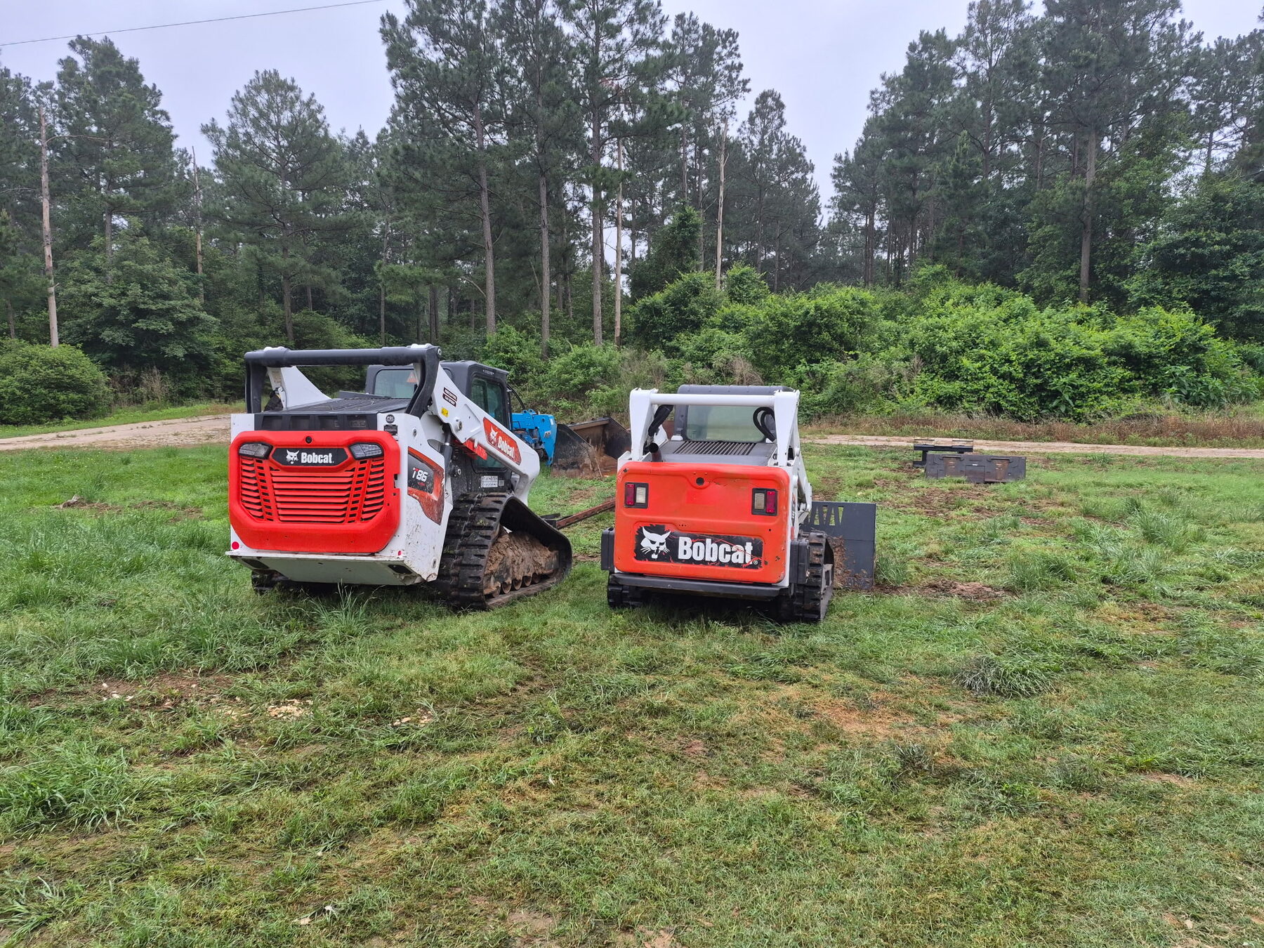 Two Bobcat track loaders on a job site
